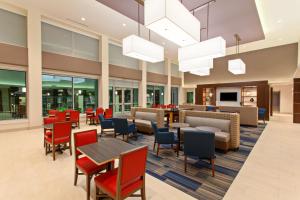 休斯顿Holiday Inn Express & Suites Houston S - Medical Ctr Area, an IHG Hotel的一个带桌椅的大堂和一间自助餐厅