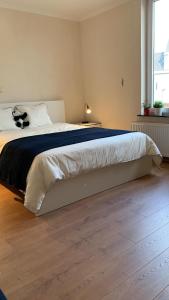 扎芬特姆Panda Stella的卧室内的一张大床,铺有木地板