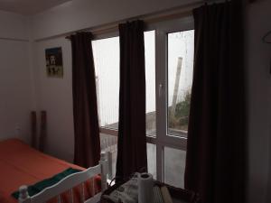 乌斯怀亚Seliuqanan的一间卧室设有窗户、窗帘和一张床