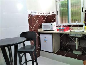 库里提巴Pousada Casa Verde - Curitiba的一间带桌子和微波炉的小厨房