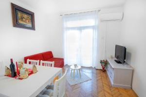 杜布罗夫尼克Ana Guesthouse的客厅配有白色桌子和红色沙发