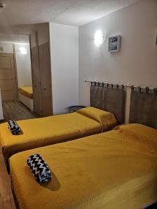 阿尔布费拉Estúdio Liberdade Albufeira的配有黄色床单的客房内的两张床