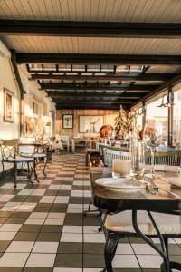 迈伦西斯岑安西酒店的餐厅设有格子地板和桌椅