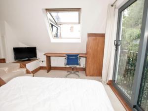 圣阿格尼丝21 British Road的一间卧室配有一张床、一张书桌和一个窗户。