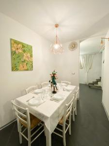 卢卡OROROSA Lucca City Center Apartment的白色的用餐室配有白色的桌椅
