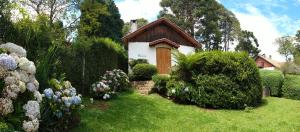 蒙特韦尔迪Chalés Monte Verde的花丛花园中的一个小房子