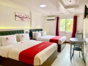 长滩岛长滩岛里迈尔樱花度假宾馆的酒店客房设有两张床和一张桌子。