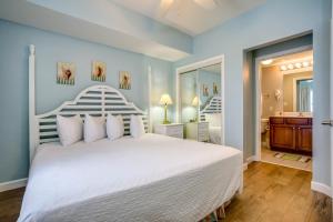 巴拿马城海滩Seychelles Beach Resort IV的一间带白色大床的卧室和一间浴室