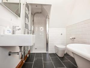 圣阿格尼丝21 British Road的白色的浴室设有水槽和卫生间。