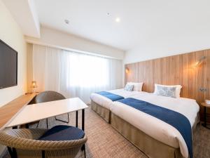 那霸Tokyu Stay Okinawa Naha的酒店客房配有两张床和一张书桌
