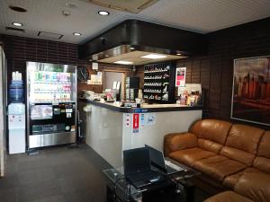 东京新宿威尔酒店的餐厅设有带沙发和冰箱的酒吧