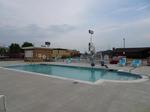 琼斯伯勒Holiday Inn - Jonesboro, an IHG Hotel的停车场的游泳池,带椅子