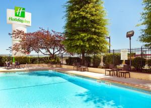 小石城小岩城假日酒店 - 总统府的一座配有桌椅的酒店游泳池