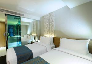 曼谷康帕斯酒店集团素坤逸13巷娜娜柑橘酒店的酒店客房设有两张床和窗户。