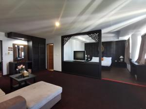 春蓬娜娜武里酒店的带沙发、床和镜子的客厅