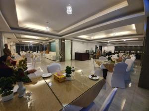 达卡贵族酒店的大型客房配有桌子和白色椅子,可供住客入住。