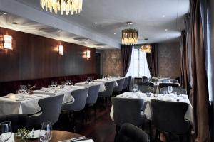 于韦斯屈莱尤普精品酒店的餐厅设有白色的桌椅和窗户。