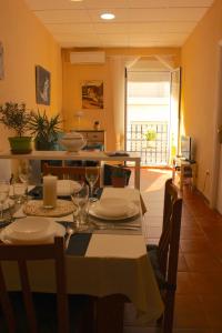 安波拉Apt ideal para familias cerca del mar的用餐室配有带盘子和玻璃杯的桌子