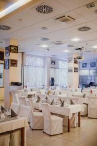 Trebnje特雷布涅银河酒店的用餐室配有白色的桌子和白色的椅子
