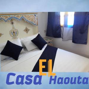 舍夫沙万Casa El Haouta的一间卧室配有一张带蓝色和白色枕头的床