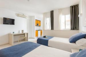 伊维萨镇Apartamentos Vibra Panoramic的酒店客房设有两张床和电视。