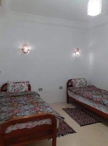 米多恩Diar Karim Djerba的一间卧室配有两张床和两块地毯。