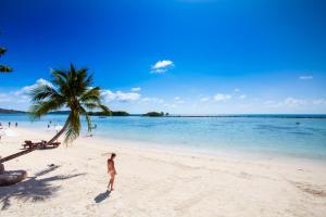 查汶The Stay Chaweng Beach Resort- SHA Plus的站在海滩上,手持棕榈树的人