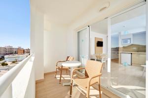 圣蓬萨阳光海滩公寓式酒店的公寓设有带桌椅的阳台。
