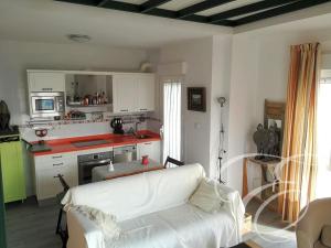 阿尔加罗沃First line beach apartment的一间带白色沙发的客厅和一间厨房