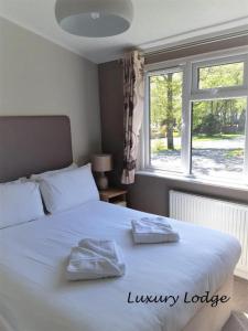 卢斯因福尔贝格假日公园酒店的卧室配有白色的床和2条毛巾