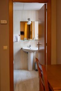 卡塞雷斯卡斯蒂利亚酒店的一间带水槽、桌子和镜子的浴室