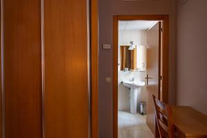 卡塞雷斯卡斯蒂利亚酒店的浴室设有门,通往带水槽的浴室