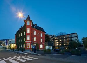 布雷根茨施瓦尔勒酒店的街上一座红色的建筑,有塔楼