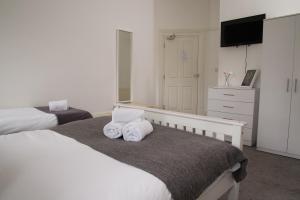 伦敦TLK Apartments & Hotel - Beckenham Junction的一间卧室配有两张床和一台平面电视