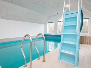乌尔夫堡16 person holiday home in Ulfborg的一个带蓝色滑梯的游泳池