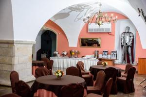 克拉西琴克拉西琴涅城堡酒店的一间设有桌椅的房间和一座位于后面的雕像