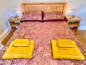 格洛索普Hawkshead Cottage的一间卧室配有一张带两个黄色垫子的床。