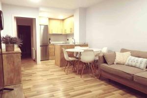 卡隆赫Apartamento Can CALET con PARKING en Sant Antoni de Calonge的带沙发和桌子的客厅以及厨房。