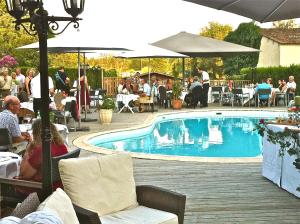 德罗讷河畔欧布泰尔佩里戈尔酒店的游泳池,人们坐在餐厅周围