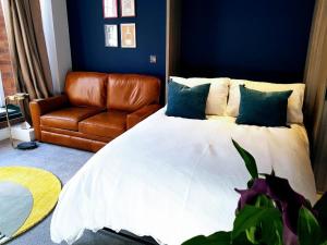 约克Cocoa Lily - River fronted studio with secure parking的一间卧室配有一张床和一张皮沙发