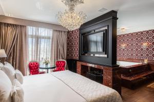 格拉玛多Hotel Colline de France的一间卧室配有一张床、一台电视和一张书桌