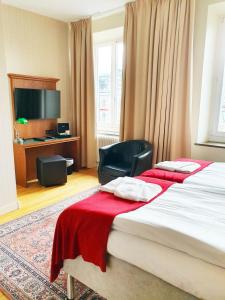 克里斯蒂安斯塔德Hotel Bishops Arms Kristianstad的酒店客房设有两张床和电视。