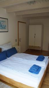 吕讷堡Gästehaus/FeWos/Boardinghaus Lüneburg Süd的一间卧室配有一张大床,上面有蓝色的毛巾