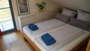 吕讷堡Gästehaus/FeWos/Boardinghaus Lüneburg Süd的床上有两条蓝色的毛巾