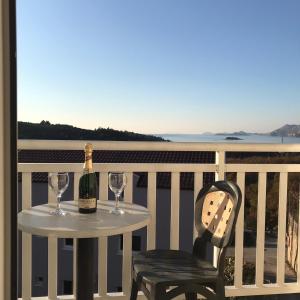 察夫塔特宾果别墅酒店的阳台上的桌子配有一瓶葡萄酒和一把椅子