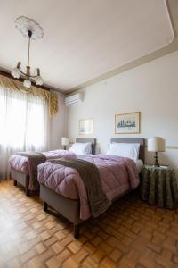 Marano VicentinoVilla Berrettini的一间卧室配有两张床和吊灯。