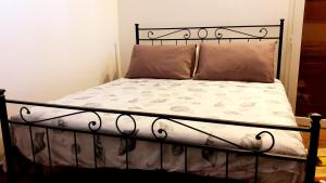 圣温琴佐Villa happy days的一张带黑色金属框架和枕头的床