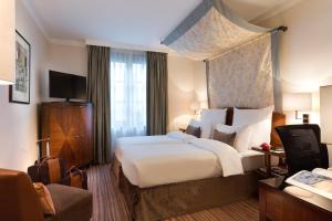 布鲁塞尔布鲁塞尔大广场华威酒店的酒店客房设有一张大床和一张沙发。