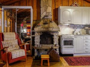 洛斯托Holiday Home Hopukka a2 by Interhome的厨房配有石制壁炉和椅子