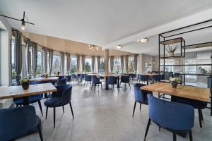 哈卡尼Hotel Arborétum的餐厅设有桌椅和窗户。